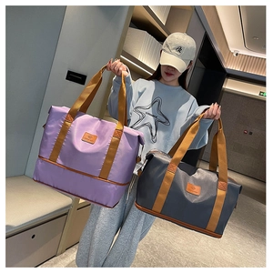 Detail of purple and grey expandable travel bags with durable fabric and brown handles