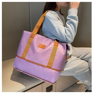 Detail of purple travel bag showing expanded bottom compartment and yellow handles
