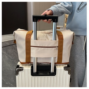 Travel bag with trolley sleeve attachment on white suitcase for fitness and short trips