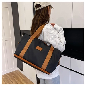 Black travel bag with brown straps, double-layer design for sports and gym use