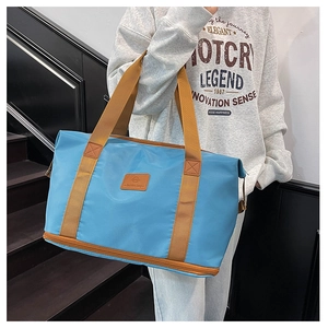 Blue travel bag detail showing the bottom zipper compartment for shoes or wet items