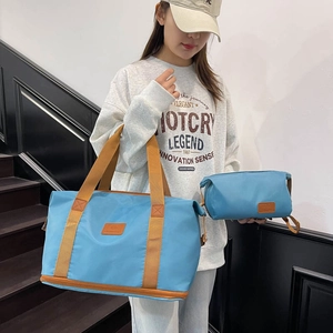 Large light blue expandable travel tote and toiletry bag set with brown handles