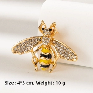Detailed macro view of a 4x3cm gold-tone honey bee brooch with rhinestones and enamel