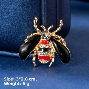 Macro detail of bee brooch showing red enamel wings and crystal rhinestones 3x2.8cm