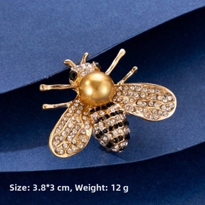 Macro shot of bee brooch with gold alloy, white crystals and pearl, 3.8x3cm size