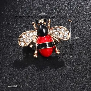 Macro shot of bee brooch with red enamel and crystals, 2.1cm x 1.4cm size detail