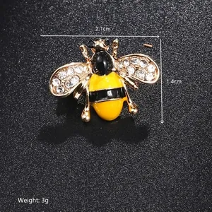 Detailed close-up of a 2.1x1.4cm crystal bee brooch with yellow enamel and 3g weight