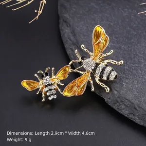 Detailed close-up of bee brooch with yellow enamel and rhinestones on black stone