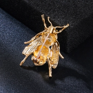 Detailed back view of gold insect brooch showing silver safety pin clasp mechanism