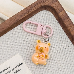 Detail of cute brown bear resin keychain holding a pink flower with a matte pink clip