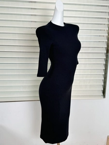 Detail of black ribbed knit dress featuring structured shoulder pads and half-sleeves