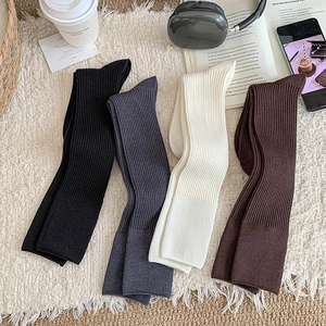 Thick cashmere knit mid-calf socks in four neutral colors on a cozy home carpet