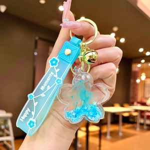 Detail of blue cherry blossom keychain with dried flowers and Happy Moments strap