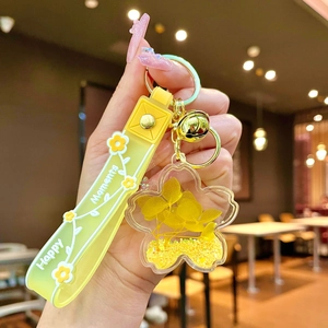 Detail of yellow silicone strap with Happy Moments text and dry flower keychain