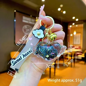 Dettaglio portachiavi a cuore liquido con glitter e cinturino in silicone rosa