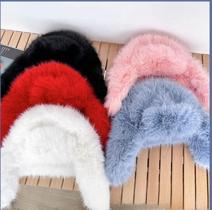 Detailed view of thick faux fur winter hats in five colors including blue and red