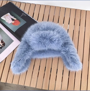 Close-up of light blue faux mink fur trapper hat with soft plush ear flaps and texture
