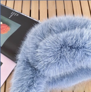 Close-up of thick light blue faux mink fur material with soft texture and glossy finish
