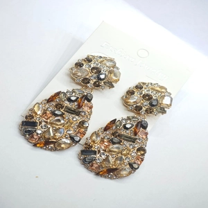 Detail of amber crystal teardrop earrings with alloy frame on a display card