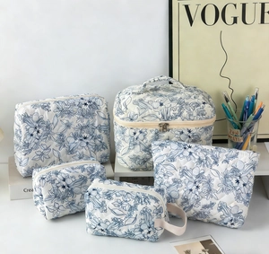 Detailed set of five quilted floral toiletry bags with navy patterns and zip closure