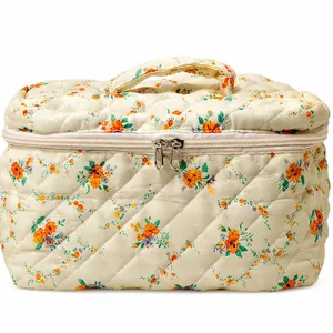 Quilted floral makeup bag with orange flower pattern and top handle for portable travel storage