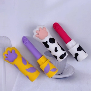 Detailed view of cute cat paw shaped lipstick erasers in various colors on white fabric