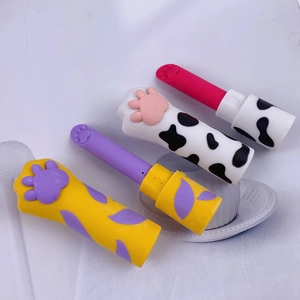 Detail of cat paw shaped erasers in yellow and white spotted lipstick style casing