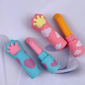 Detail of cute cat paw lipstick-shaped erasers in pink and blue pastel cases