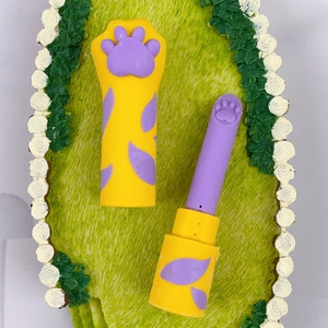 Detailed view of cat paw eraser featuring purple 3D paw details and a yellow lipstick tube