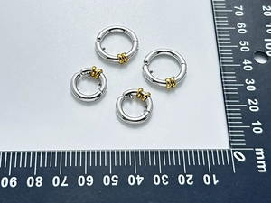 Vue détaillée de boucles d'oreilles clips bicolores avec règle de mesure de précision