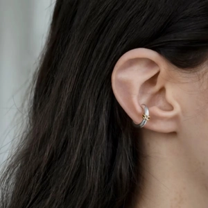 Vue détaillée d'une boucle d'oreille bicolore en or et argent sur l'oreille