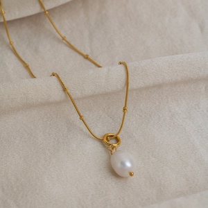 Elegant gold beaded snake chain necklace with a natural white baroque pearl pendant