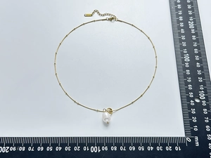 Detail of freshwater pearl pendant necklace showing S925 stamp and adjustable chain length