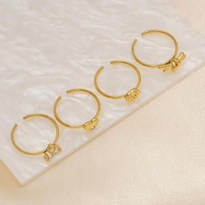 Set of four adjustable 18K gold plated rings featuring rose, heart, and knot designs