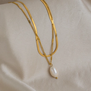 Double-layer gold stainless steel necklace featuring a flat snake chain and baroque pearl