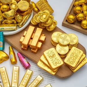 Close-up of festive chocolate gold coins and ingots in bright gold foil packaging