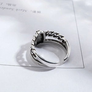 Macro shot of silver vintage chain ring with flame patterns and oxidized industrial finish
