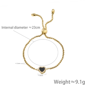 Adjustable golden heart bracelet with black enamel and zircons on white background