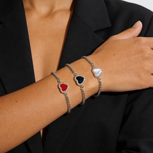 Silver-toned heart bracelets with red, black, and white stones on a black blazer background
