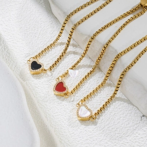 Detailed macro of gold twisted chain bracelet with crystal heart charms in various colors