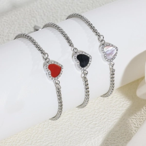 Three heart charm bracelets in red, black, and pearl white with pavé stones on a round chain