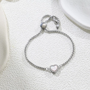 Detailed macro view of silver heart bracelet with pearl center and adjustable slider clasp