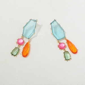 Détail des boucles d'oreilles géométriques bohèmes avec cristaux colorés et monture dorée