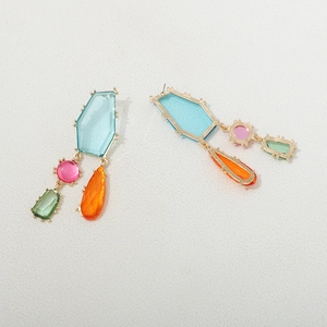 Détail macro de boucles d'oreilles géométriques en cristal avec monture dorée