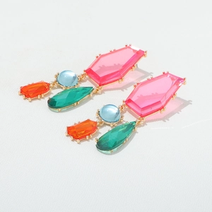 Gros plan de boucles d'oreilles pendantes géométriques avec cristaux multicolores