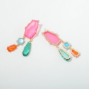 Gros plan de boucles d'oreilles géométriques en cristal avec pierres colorées et monture dorée