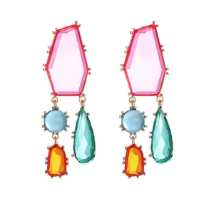 Détail de boucles d'oreilles géométriques en cristal avec pierres colorées et dorure