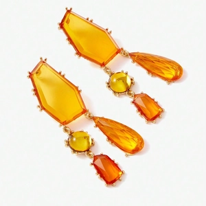 Gros plan détaillé de boucles d'oreilles en cristal ambre avec facettes géométriques