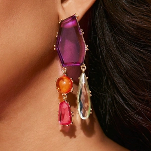 Gros plan de boucles d'oreilles géométriques en cristal avec pierres multicolores