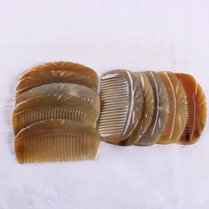 Macro detail of amber-colored natural ox horn comb with intricate floral carvings